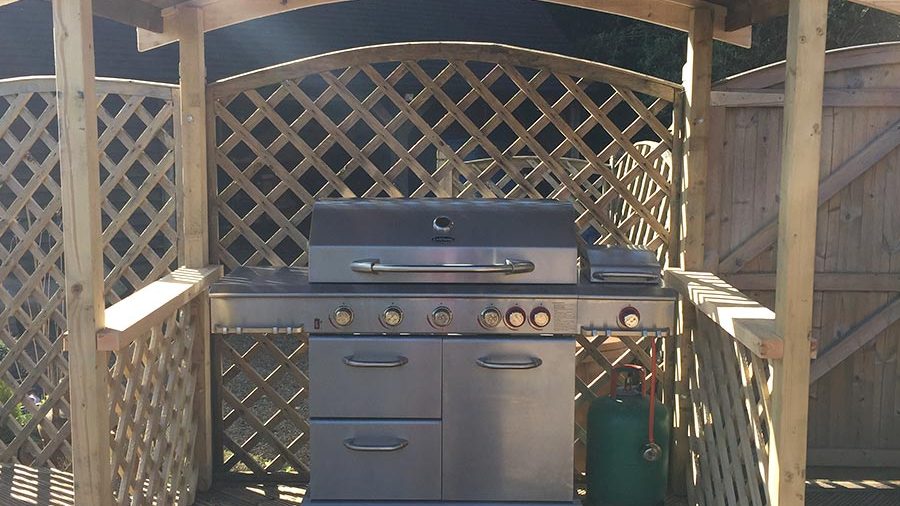Barbecue pergola surround with trellis work, in a back garden in Ampfield