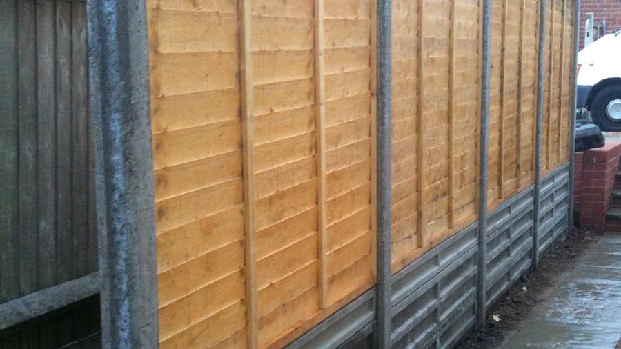 Repair to waney edge panel fencing with concrete posts and gravel boards, Eastleigh