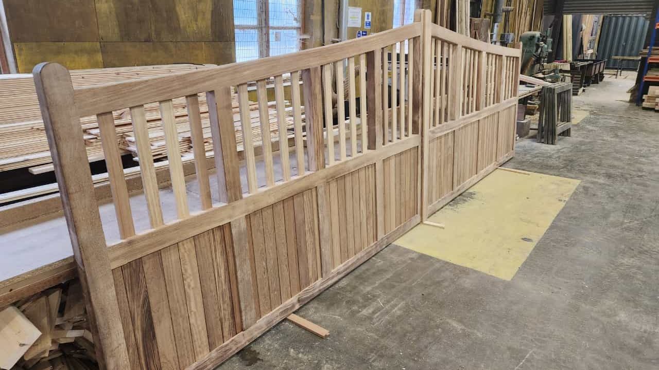 Over-sized custom-built hardwood Iroko gates built on a metal frame for a grand driveway entrance with automation